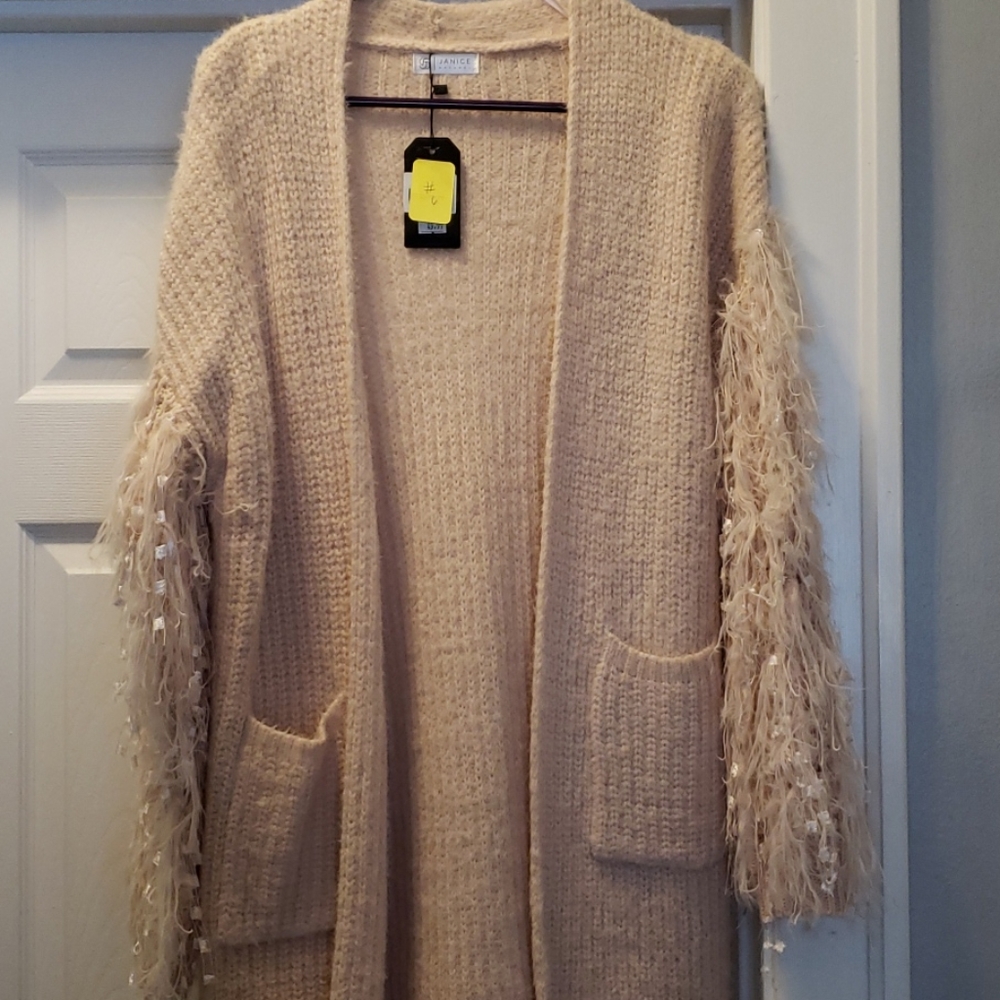 Brand new sweater cardigan with frilly sleeves.